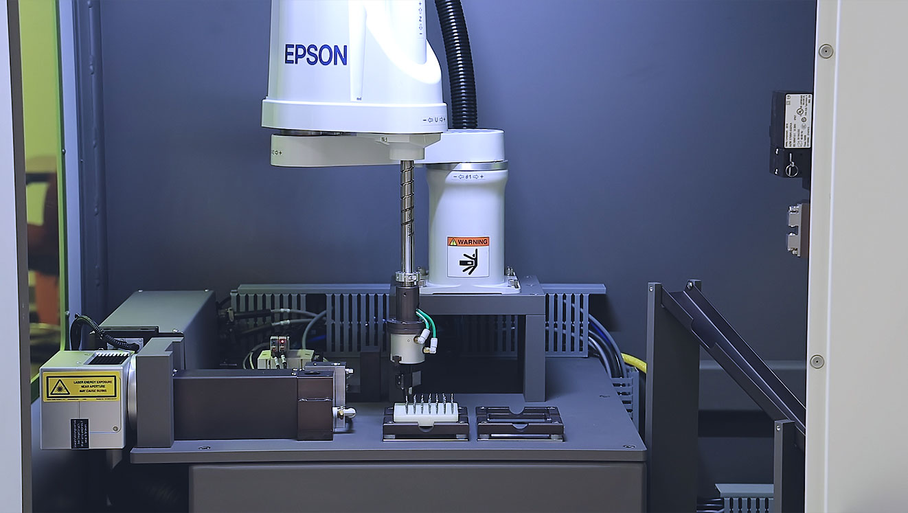 Automated laser marking machine with robotic part handling for titanium dental drill bits