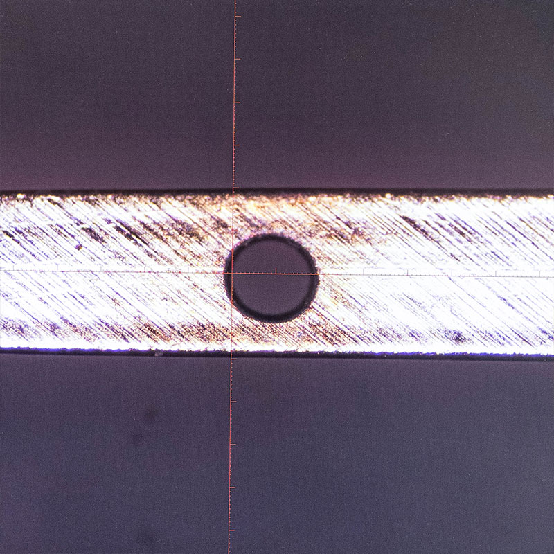 Laser drilled hole in thin metal wire