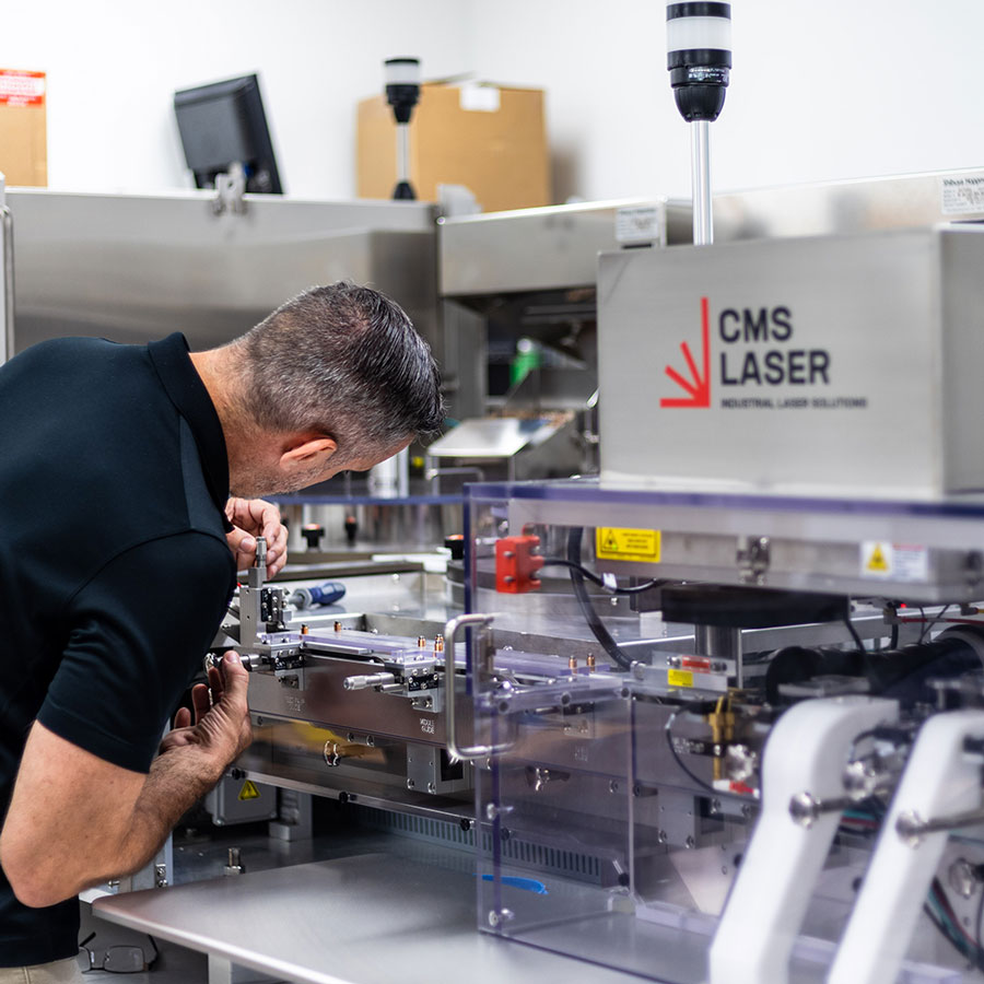 CMS Laser field service engineer working on a laser drilling system for pharmaceuticals